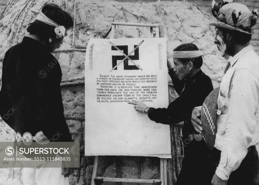 Arizona Indians Ban The Swastika Because of Nazi "Acts of Oppression" Indians Studying the Proclamation banning the use of the swastika displayed at a Ceremony at which blankets and clothing bearing the now unpopular symbol were burned. Left to right, Charley Turquoise (Navajo Indian), ***** (Apache Indian). Displeasure over Nazi "Acts of oppression" has led four Indian Tribes to Forswear the use of the Indian Swastika design on their blankets and baskets, in spite of the fact that the Indian S