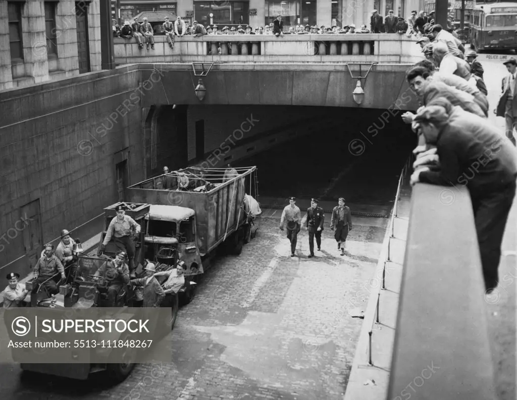 Haul Wrecked Truck From Tunnel. A New York port Authority vehicle hauls a truck from the Manhattan entrance of the Holland Tunnel in New York, May 13. Earlier an explosion of drums of chemicals on another truck set off a fire which spread to other trucks in the under water Tunnel. Capt. Philip N. Edwards, General superintendent of Tunnels and bridges for the Authority, said late May 13, "There is no chance for the New York bound Tunnel being re-opened tonight." Eleven trucks were damaged in the