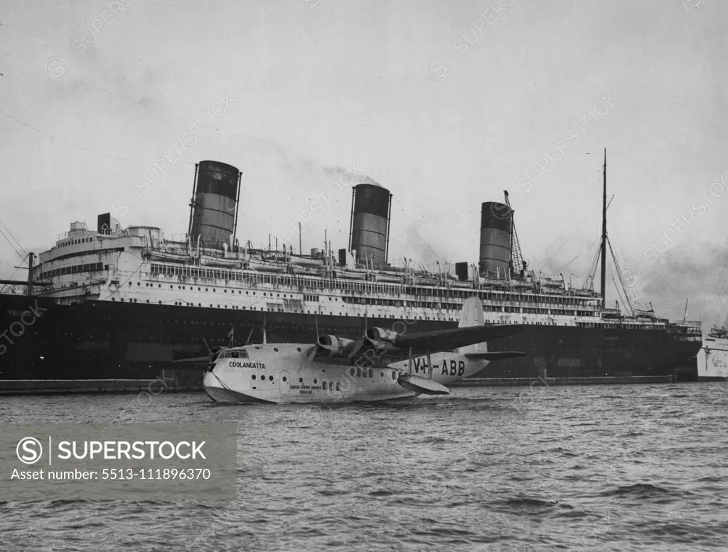 Arrival From Australia - Passes By Doomed Sea Giant -- Coolangatta, one of the fleet of Empire flying-boats, taxi-ing past the "doomed" liner Berengaria at No. 108 Berth in the New Docks at Southampton, at the end of her 12,000-,iles journey from Sydney. The Coolangatta was a day behind schedule when she was handed over by her Qantas Empire Airways' pilot to Captain I.G. Ross of Imperial Airways, at Singapore. The lost time was made up on the remainder of the journey, which was accomplished in f