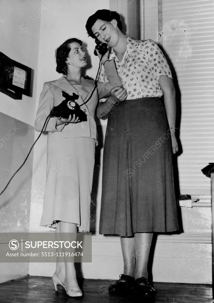 Members of the tall Girls' club held ***** since the club was formed in July at the Buck's ***** night. Twenty-five girls over 5ft. 9 in. have joined ***** and their aim is to get manufacturers to make clothing suitable for girls of their height. Here during the meeting. Marlene Broad (left) hands the telephone to the club's tallest member, Pat Reid. January 12, 1955. (Photo by "The News" and "The Mail" Adelaide).