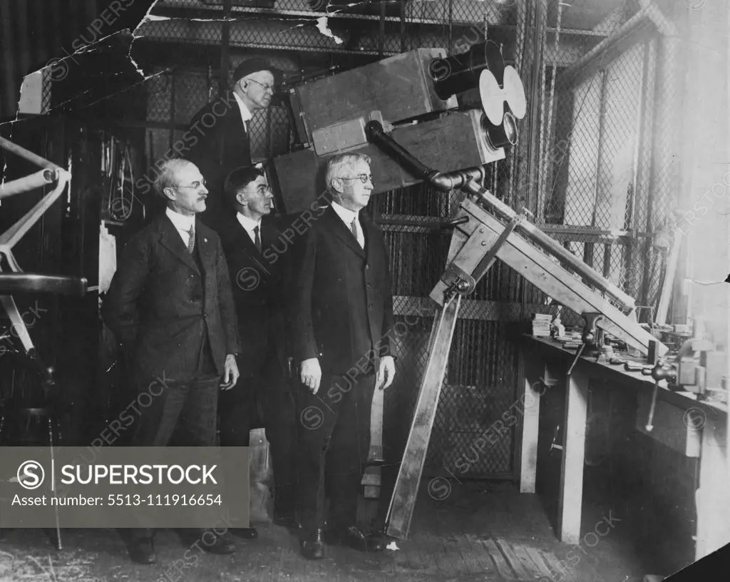 Navy Scientists to Photograph Sun's Eclipse -- Above is shown the giant camera by means of which navy scientists hope to photograph the eclipse of the sun, which is expected to take place january 24th. the huge camera has been specially constructed for this test, to be made from the naval dirigible shenandoah. In the foreground is captain E.T. Pollock, superintendent of the U.S. Naval observatory, who is to be in charge of the tests. At the camera is shown the navy photographer. George H. Peters