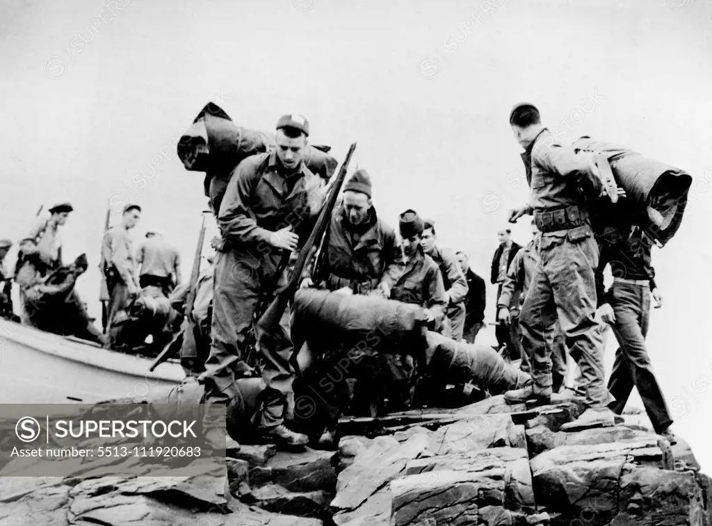 Coast Guardsmen Search for Enemy in Greenland.A Coast Guard landing party goes ashore on Greenland in recent action which led to the capture of 60 Germans and the destruction of enemy radio-weather stations. The men are, from the left: Allen J.Elmergreen, seaman 1/c (with Gun), of 1166 Superior Ave., Sheboygan, Wis.; John Baker, soundman 3/c, of 1661 Robinwood Ave., Lakewood, O.; Walter D. Harris, Yeoman 1/c, of Isabella, Tenn., and George English, Motor Machinist's mate 2/c (Back to camera), of