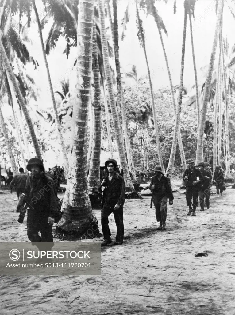 U.S. Troops Move by Plane to Attack in New Guinea:Troops move up to the front through a Papuan village after being flown in by a U.S. Army transport plane. March 22, 1943. (Photo by Interphoto News Pictures, Inc.).