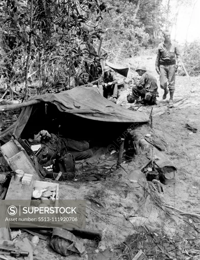 An advanced post in New Guinea maintains constant contact with headquarters in the rear by telephone communication. Here an American soldier near the front lines is shown contacting his headquarters. February 15, 1943. (Photo by Signal Corps U.S. Army).