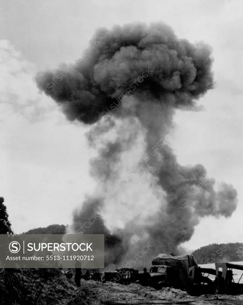 American lined up on beach at Humboldt Bay. Burning Japanese stores threw a pall of smoke over beach as American troops capture Japanese held Hollandia in Dutch New Guinea. April 25, 1944.