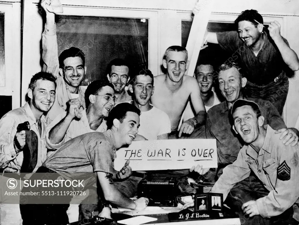 GIs Cheer Japan's Peace Bid -- Jubilant servicemen at Cincpac Advance Headquarters on Guam cheer as they listen to the radio announcement of Japan's bid for peace under the terms of the Potsdam declaration. The news reached men in the Central Pacific Area at 10:18 p.m. August 10. Left to right are: PFC William Thompson, AUS, Richmond, Va.; T/5 Carl Gurtcheff, AUS, Philadelphia, Pa., Cpl. Vic Colucci, AUS, Brooklyn, N.Y; Arthur Ryding, PhoM 2/c, USNR, of Lawrence, Mass.; Clifford Martin, PhoM 2/c