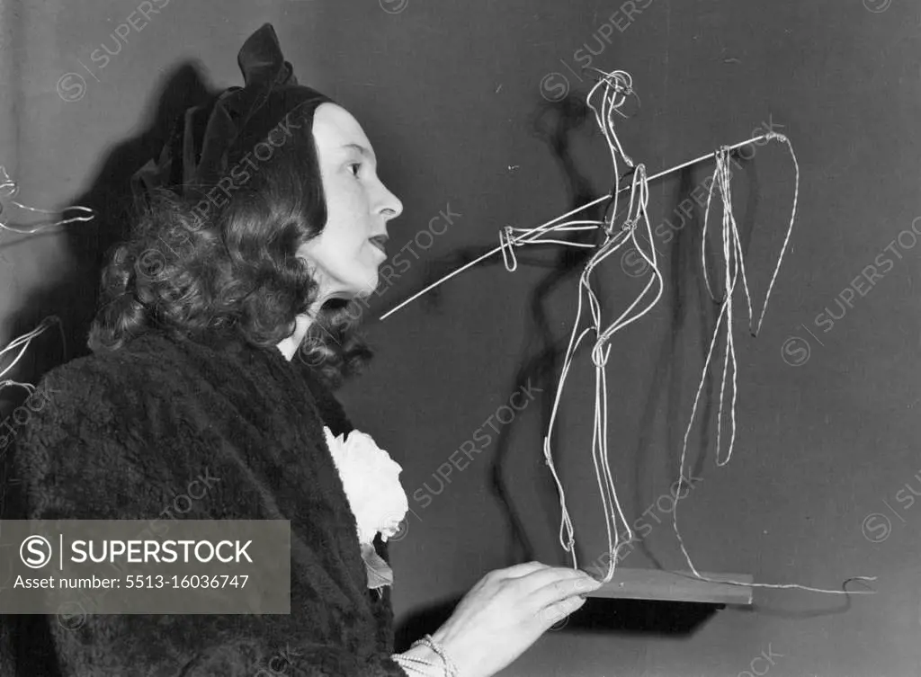 Fashions Art In Wire -- Miss Wendy Soiling, the young Australian sculptress, views her "Bullocky and his Whip" - one of the wire 'sculptures' on show at her first London exhibition, being held at the Galerie Apollinaire, Charing Cross Road. Many of Miss Solling's works are made of wire. She twists and fastens fencing wire into shape. Claims rusting does not detract. Three times postponed owing to fuel restrictions on lighting, the exhibition was opened by Mr. Harrison, Resident Australian Minister in London. February 15, 1951.