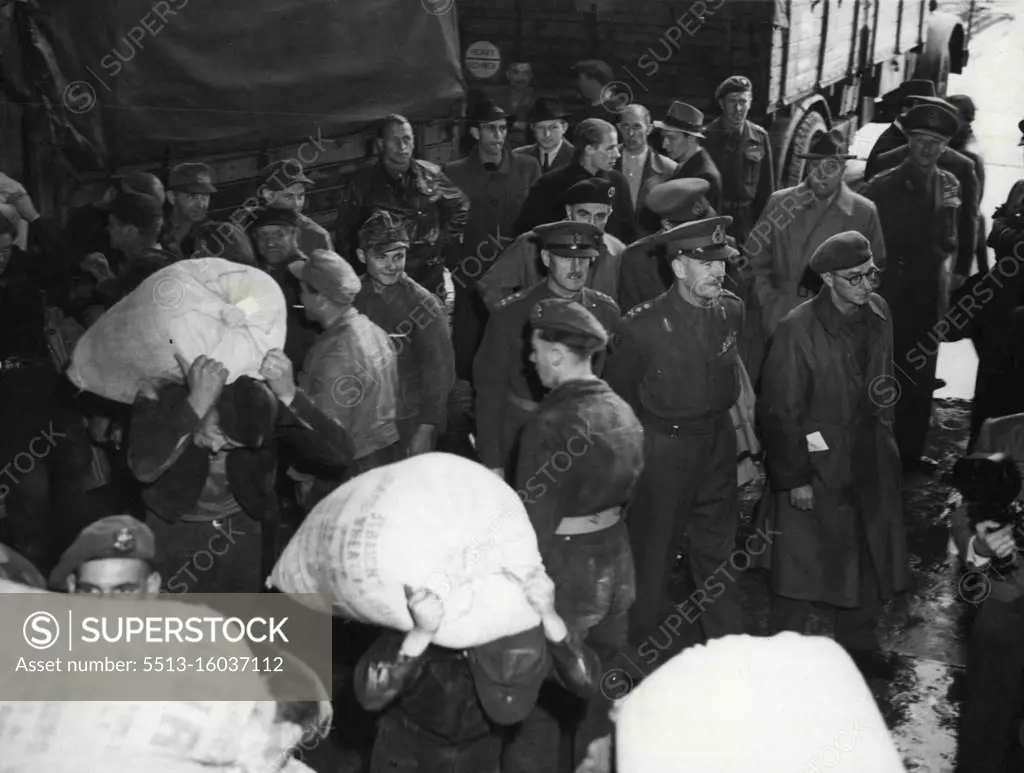 Gen. Robertson Inspects Food Base For Berlin -- General Sir Brain Robertson, British Military Governor in Germany, centre of three officers, watches German workers carry sacks of flour to awaiting aircraft at Wunstorf Airport, near Hanover, Germany, base for supplying food by air to Berlin. Day and night a constant stream of aircraft leave Wunstorf for Gatow, Berlin, taking in supplies of food for the two million German in the Western sectors of the German Capital in the face of the closing by Russia of land routes into the city. July 4, 1948. (Photo by Associated Press Photo).