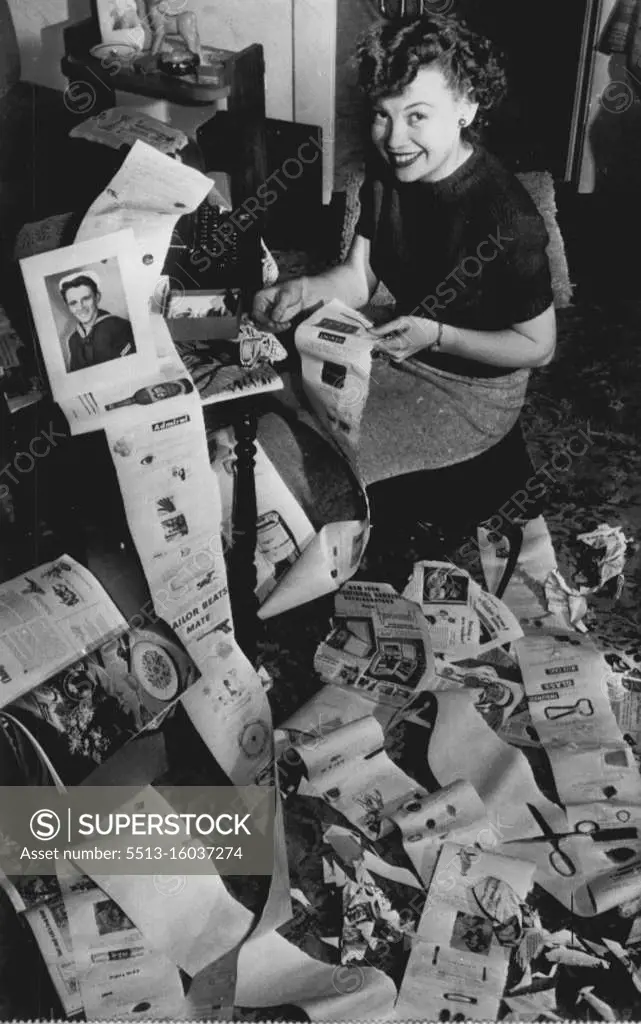 "Postoffice" by Long Distance. Betty Adams (above), 18, thinks she has an answer to her fiance's complaints that her letters are too short: An epistle 36 feet long and weighing five pounds. She finished it today and it's going off to Donald W. Jackson, 21, of Denver, a fireman aboard the U.S.S. Wisconsin at Portsmouth, Va. Betty typed the letter on shelf-lining paper and pasted on it photos, clippings, razor blades, sticks of gum and other knick-nacks. March 20, 1951. (Photo by AP Wirephoto).