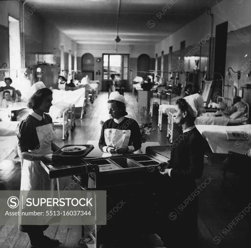 Life And Work Of A Hospital Matron -- On her rounds, the Matron has a word with Sister O. Broadhurst who is serving the patients' mid-day meal. Though Orderlies now assist the nursing staff in carrying trays to the bedside, as sell as in many other duties, the management of the patients' diet is still considered an important part of a nurse's work and the student nurse in this picture is learning the practical side under the personal supervision of Sister. November 22, 1950. (Photo by Tom L. Blau, Camera Press). 