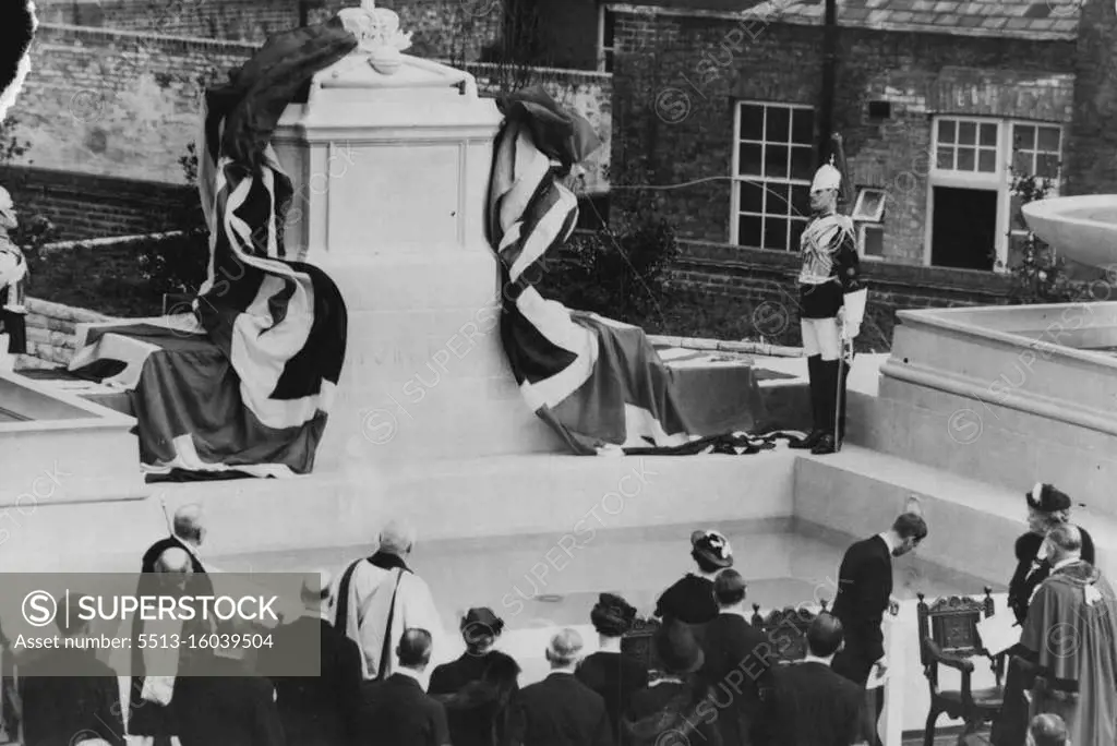 King Unveils Windsor's Memorial To His Late Father -- The memorial being unveiled. On the extreme right is Queen Mary. Opposite her King George VI is seen operating the Mechanism which pulled away the flags. Behind him are the Queen (with white decoration on her hat) and the other members of the royal family. The Archbishop of Canterbury is standing in center. The King, in the presence of the Queen and all other members of the Royal family in England, unveiled the town's memorial to the late King George V here this afternoon. It consists of a marble cenotaph with a stone surround and two fountains. May 10, 1937. (Photo by Associated Press Photo).