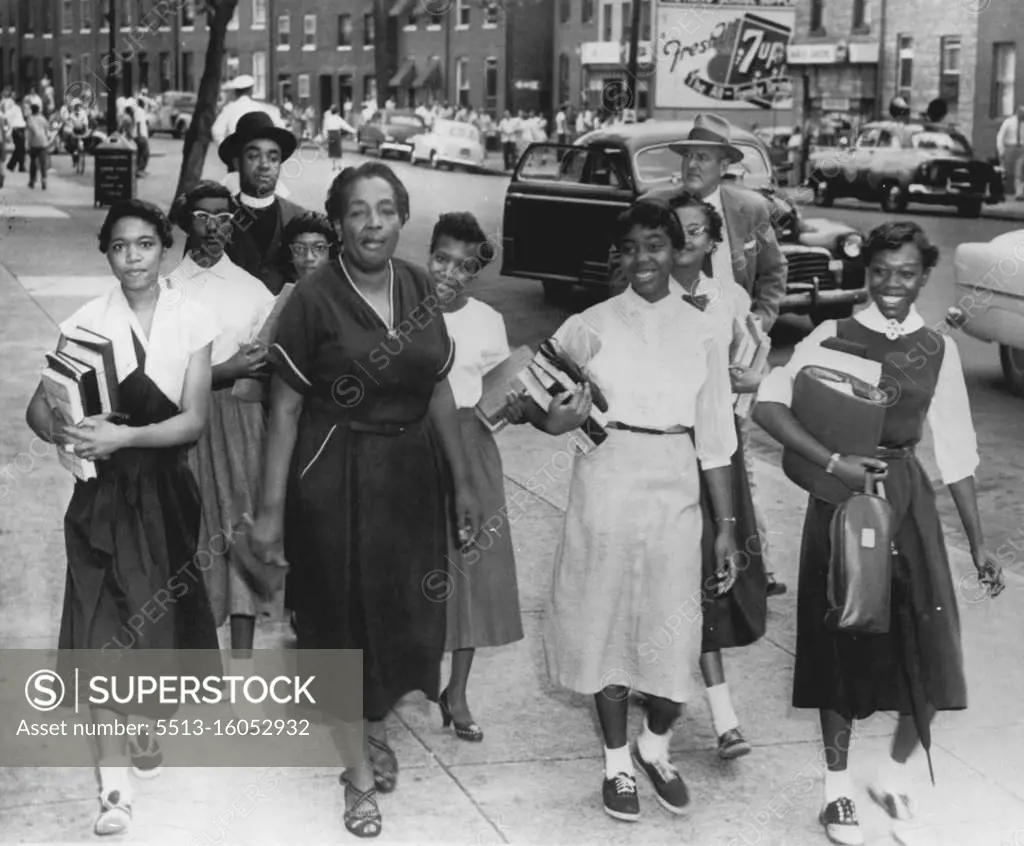 On Their Way To School -- Students returned to classes at Southern High School today, accompanied by ministers and parents. Heavy details of police patrolled the area, scene of an angry demonstration Friday by a crowd of several hundred whites protesting integrated classes. A police cruiser, equipped with loud speakers (background, across street) warned today against unlawful assembly. October 04, 1954. (Photo by AP Wirephoto).