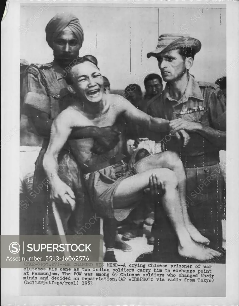 He Changed His Mind -- A crying Chinese prisoner of war clutches his cane as two Indian soldiers carry him to exchange point at Panmunjom. The POW was among 65 Chinese soldiers who changed their minds and decided on repatriation. September 27, 1953. (Photo by AP Wirephoto).