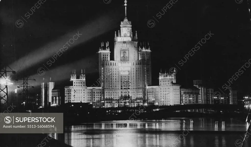 Building in the Soviet Union: A Skyscraper block of flats in Moscow the new 32 - storey. 700 - flat building on the Kotelnicheskaya Embankment. It is one of eight gigantic buildings now under construction in the soviet capital. Its first Tenants moved in at the end of December 1951.Among the amenities are garages for prams, bicycles and for Private cars: there is also a cinema with 400 seats. It is a steel and concrete building. - Note the huge Portrait of Stalin floodlit on the front of the block of flats. July 11, 1952. (Photo by Camera Press)