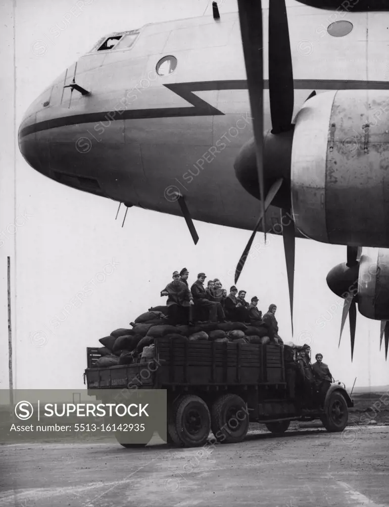 Fuel For Berlin By The Airlift Coalmen -- A lorry loaded with sacks of coal passes under the nose of the "aerial coalman", a giant Ha stings aircraft, at Schleswigland. The first of the new giant air freighters, the Royal Air Force Handley Page Hastings, are now being used on the air lift to Berlin, Germany. They are operating from the ex-Luftwaffe night-fighter station at Schleswigland where 19,000 tons of soil has been remove and 7,000 tons of concrete laid in the last 15 days to get the aerodrome ready for the giant aircraft that can make the trip to Berlin in one hour and carry a load of nearly 7½ tons. November 03, 1948. (Photo by Reuterphoto).