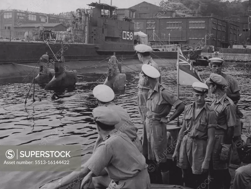 Captain H.J. Buchanan D.S.O., R.A.N. Commander of the British Landing Force and staff having a close up midget submarines surrendered in the Japanese Naval Base of Yokosuka. These midgets were used in the attack on Sydney in June, 1942. August 30, 1948. (Photo by Australian Official Photo).