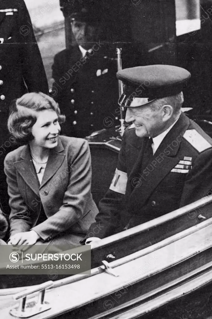 Princess On The Rever - A happy picture of Princess Elizabeth chatting with rear-admiral Sir Basil Brooke during the trip. Princess Elizabeth and Princess Margaret Rose had a break from lessons to day when they made a trip by launch on the Thames. January 21, 1943. (Photo by L.N.A.).