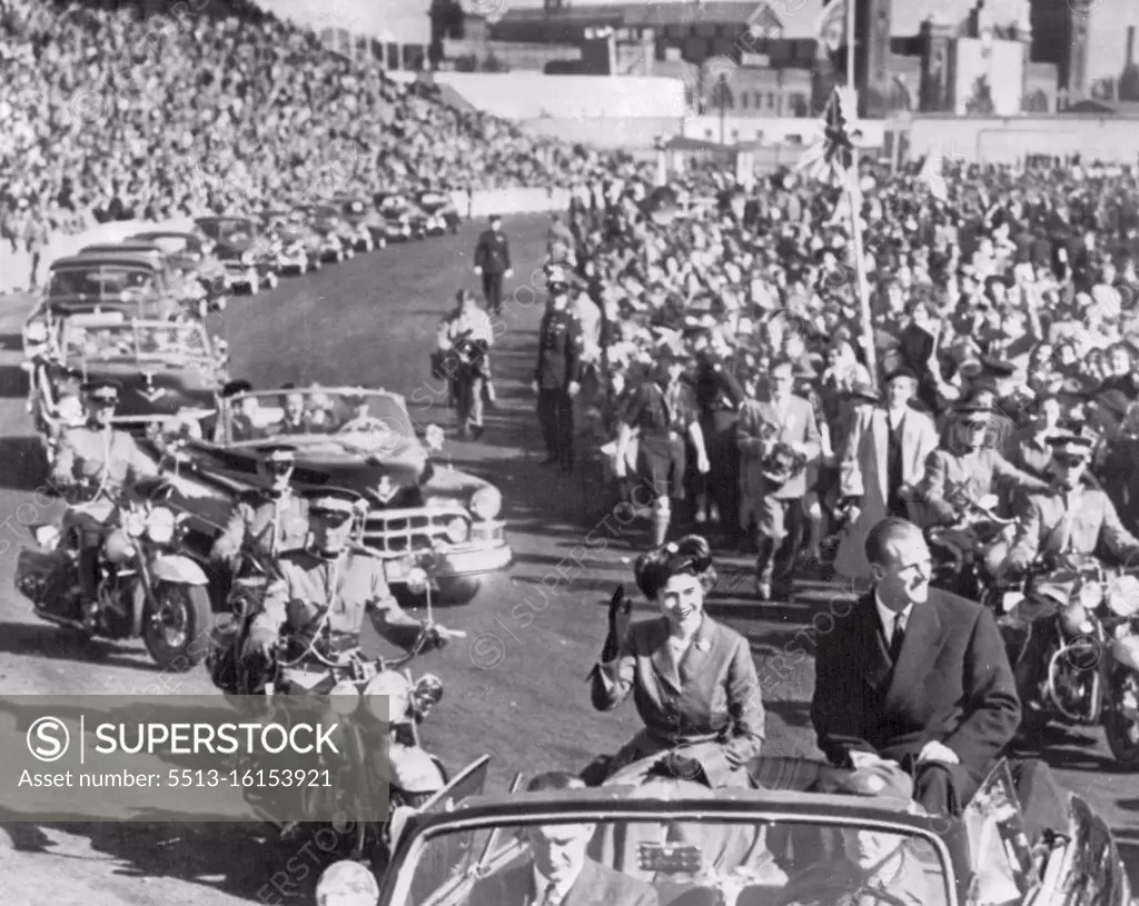 Royal Couple Atop Car -- Princess Elizabeth and Duke of Edinburgh wave from atop their car on entering the Canadian Exhibition Grounds this morning. Thousands of school children and grown-ups jammed the arena to watch a glimpse of the Royal couple. October 30, 1951. (Photo by AP Wirephoto).