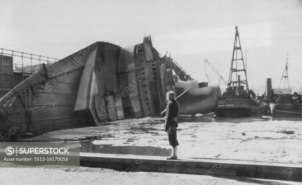 Normandie Quarded -- A U.S. sailor stands guard at one point of the pier slip where the Normandie lies on its side, victim of fire. Salvage tugs crowd about the liner -- renamed the Lafayette when the U.S. took it over. February 26, 1942. (Photo by AP Wirephoto).During World War II, Normandie was seized by U.S. authorities at New York and renamed USS Lafayette. In 1942, the liner caught fire while being converted to a troopship, capsized onto her port side and came to rest on the mud of the Hudson River at Pier 88