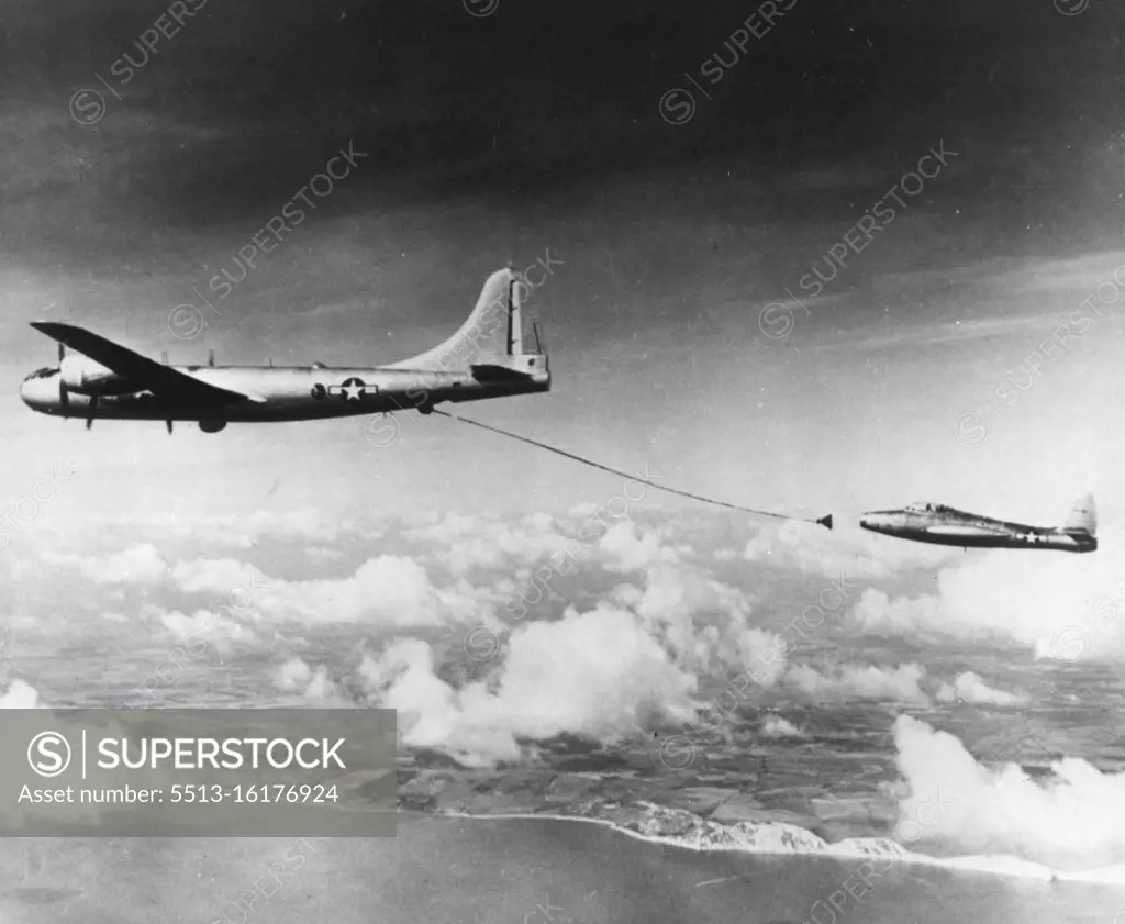 How Jets Refuel on Atlantic Flight -- A B-29 tanker plane with a fuel hose trailing out behind it is abut to make contact with an F-84 jet fighter in practicing the refueling operation being used on today's London-to-New York flight by two single-engine jets. Te jet plane here is one of the two making the flight. In the operation, the jet pilot rams a small boom extending from his wing into the funnel-shaped nozzle at the end of the tanker's hose. September 22, 1950. (Photo by AP Wirephoto).