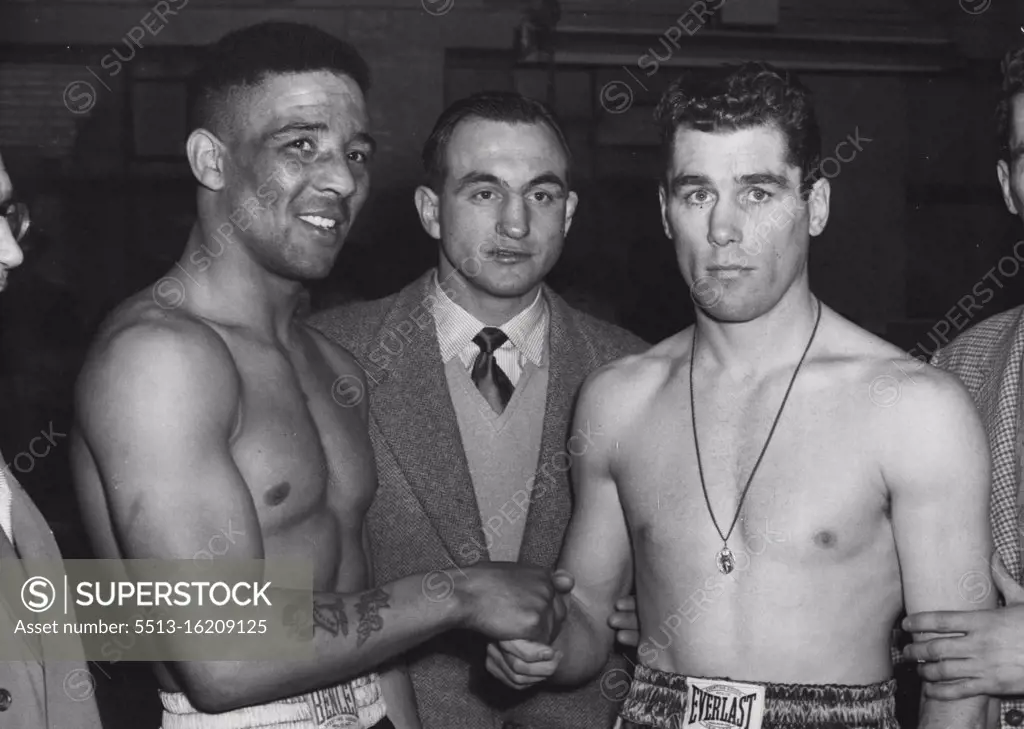 Weigh-in For The Big Fight. A shake-hands at their Solomon's Gymnasium weigh-in to-day (Tuesday) between Britain's Randolph Turpin and America's Walter Cartier (Right) who meet to-night at London's Earl's Court. Looking on in centre is Charles Humez, French middleweight, listed as Turpin's world-title opponent at the White City on June 9th. He will be watching the fight to-night. On the right is Vince Cartier, Walter's lawyer-brother. March 17, 1953. (Photo by Planet News Ltd.).