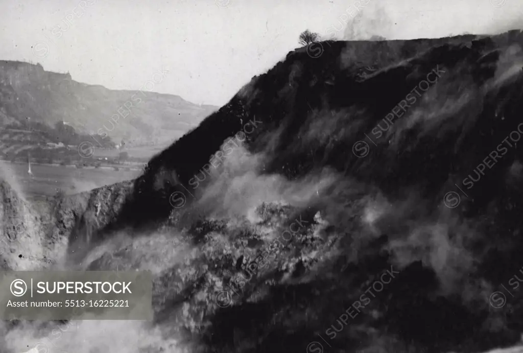 Big Perth Quarry Blast -- A striking view of the blasting operations in progress at Perth. yesterday. Central Scotland's largest quarry blast ever took place yesterday at the Perth Quarry, where, it is estimated, 80,000 tons of whinstone were disloged. Rail and road traffic were held up during the great blast. March 26, 1938. (Photo by Topical Press).