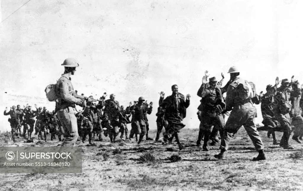 Italians Surrender to British in Tunisia. Their hands up raised, a group of Italian soldiers surrender to Tommy-Gun carrying Eighth Army during the British drive northward in Tunisia **** his group was said to have been ***** 20,000 prisoners captured ***** Army between March 20 and April 12. May 17, 1943.