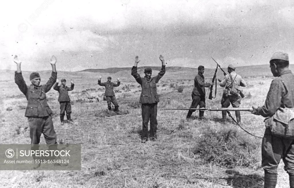 Nazi Prisoners in Russian Hands. Nazi troops who have been hiding in the fields in the Northern Caucasus area are found in mopping up operations and surrender to two Russian solders. March 18, 1944. (Photo by Pictorial Press).