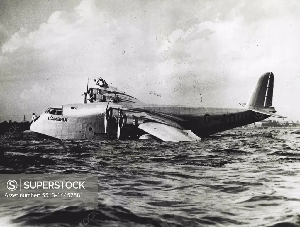 Imperial Airways Ship Crashes At Toronto - Members of the crew on the wing as the boat drifted to a stop. The Imperial Airways flying boat Cambria, which has successfully crossed the Atlantic Ocean three times, crashed in her landing at Toronto, Canada, September 3rd, when the gaint craft hit a floating landing, tearing a hole in one pontoon. The crew immediately took positions on the right wing, to counterbalance the damaged pontoon and save the craft from more serious disaster. September 5, 1937. (Photo by ACME).