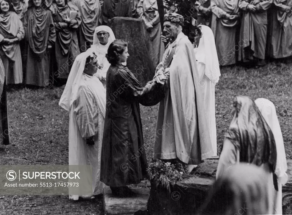 Princess Elizabeth Invested As A Bard -- The Princess receives her Gorsedd title from the Archdruid placing her hands between his. H.R.H. Princess Elizabeth was this morning invested as Honorary Ovate of the Gorsedd of the Bards of Wales, at a ceremony at Mountain Ash. Glamorgan, under the title 'Elizabeth of Windsor'. August 06, 1946. (Photo by United Kingdom Information Office).