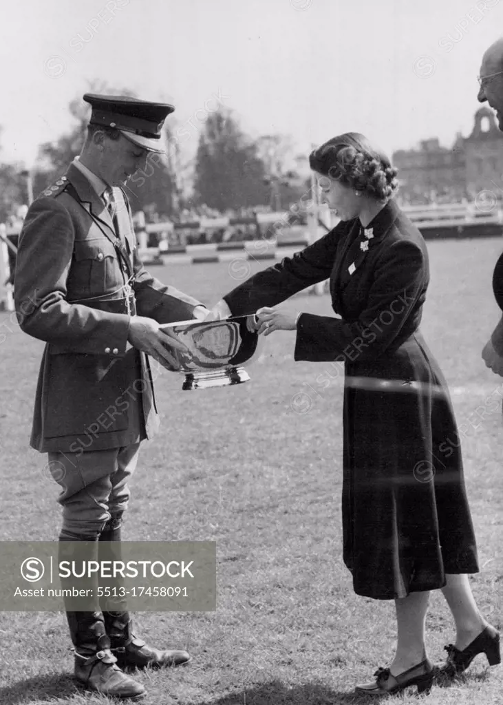 The Queen Presents The Trophy To Guard Winner At Badminton -- HM the Queen photographed yesterday, Friday, presenting the trophy to Captain H.A.Q. Darley, of the Royal Horse Guards, winner of the three-day equestrian test at Badminton. The Queen, the Duke of Edinburgh and Princess Margaret, at present staying at Badminton House, Glos., as guests of the Duke of Beaufort, have been spectators at the British Horse Society's Olympic Trials held i the grounds of their host's estate for the past three days. April 26, 1952. (Photo by Fox Photos).