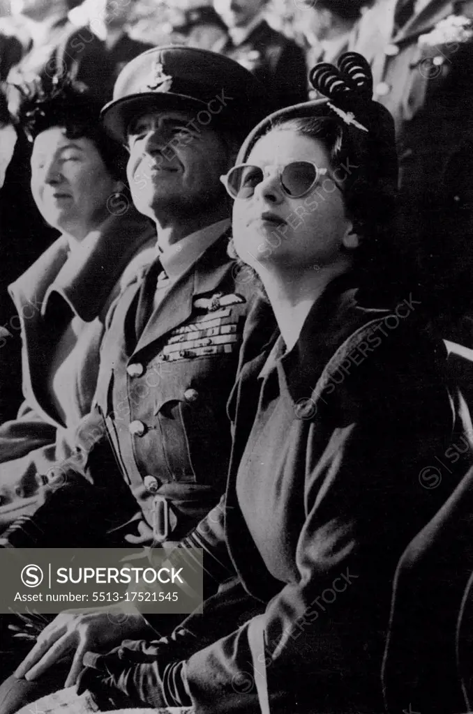 Princess Elizabeth Visits The R.A.F. - Princess Elizabeth - with Air Marshal Sir Basil Embry, Air Officer Commanding-in-chief, Fighter Command - Wears sun-glasses as she watches a demonstration of aerial acrobatics and high-speed flying, during a visit to the headquarters of the Royal Air Force Fighter Command, at *****, Middlesex. The Princess is wearing the "Winge" of the R.A.F. as a brooch on her hat. November 18, 1950.