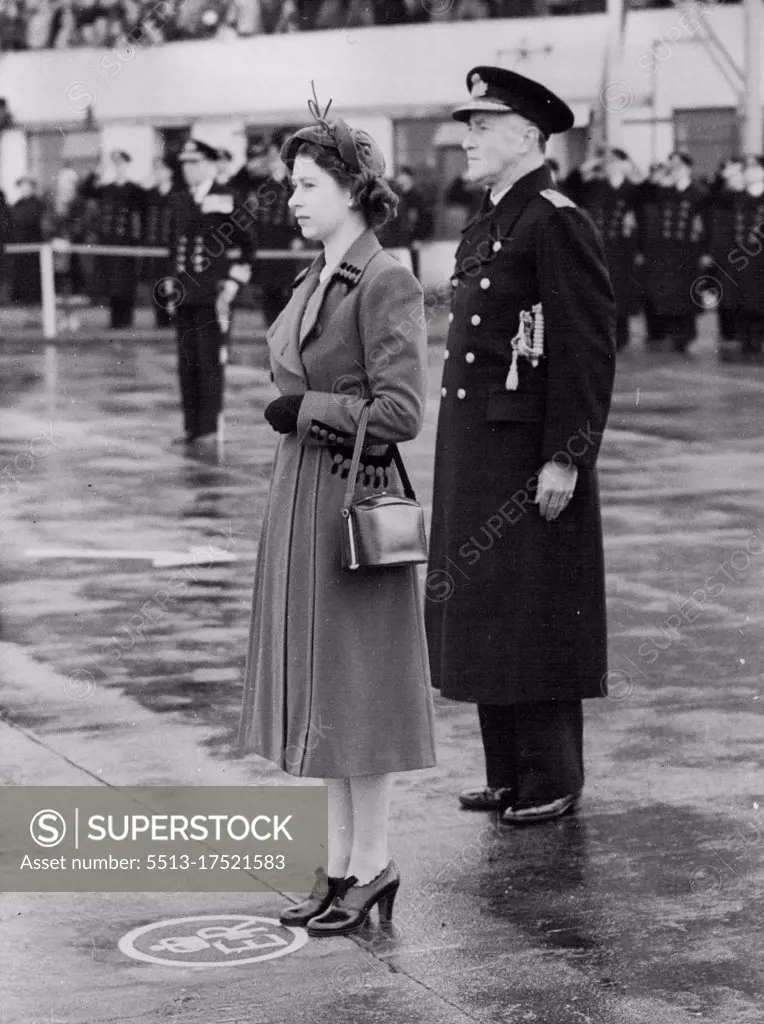 The Queen Takes The Salute: The Queen, standing on a specially-marked spot bearing the Royal Oypher, takes the salute at Lee-on-Solant today (Friday). Behind her is the flag officer air (Home), Vice-Admiral C.E. Lamre. Paying her first visit to a naval establishment since her Accession , The Queen today (Friday) visited The Royal Navy's Home Air Command at Lee-on-Solent, Hampshire. She travelled from London by rail to Fort *****, completing her journey by car, which was escorted by two S.51 Weatland Sikeraky Dragonfly helicopters - the type that has been operating on rescue work behind enemy lines in Korea. November 21, 1952. (Photo by Reuterphoto) 