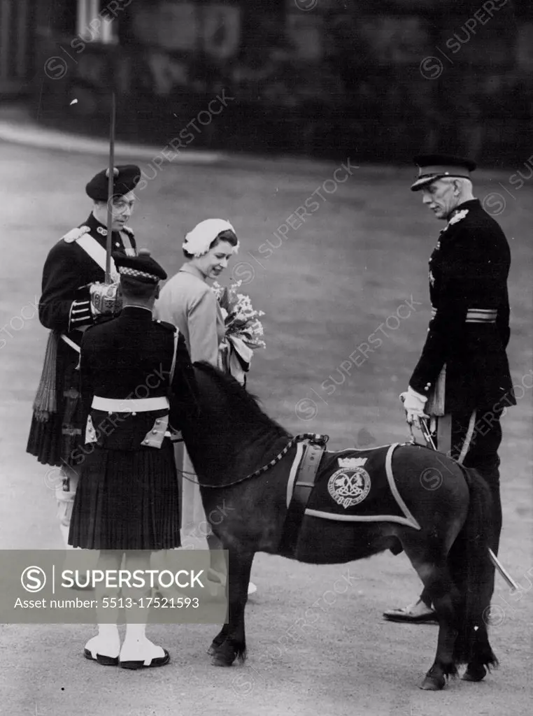 The Queen, holding a bouquet, turns to look at Cruachan he is no ordinary pony - at Holyroodhouse, Edinburgh, yesterday, the land pony Cruachan was on parade because he is the mascot of the Argyll and Sutherland Highlanders. Recently back from Korea, the Argylls formed aguard of honour when the Queen and the Duke of Edinburgh arrived. With the Queen is General Sir Colin Barber (right), head of Scottish Command. June 24, 1953. (Photo by Daily Mirror).