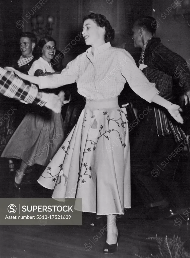 The Princess Goes Gay At Ottawa Barn-Dance -- A check-shirted partner swings the gaily dressed and happily smiling Princess round during the barn-dance at Rideau Hall, to toe shouted Instructions of the "caller". The official aspect of the Royal tour of Canada was relaxed on Friday October 12th, when Princess Elizabeth and the Dike of Edinburgh attended a traditional barn-dance held at Rideau Hall, Ottawa, home of the Governor General, Viscount Alexander. The royal couple alone with the rest of the guests, wore the accepted barn-dance costume, the Princess a dirndl skirt and peasant blouse, the Duke blue jeans, checked shirt and neckerchief. October 15, 1951. (Photo by Fox Photos).