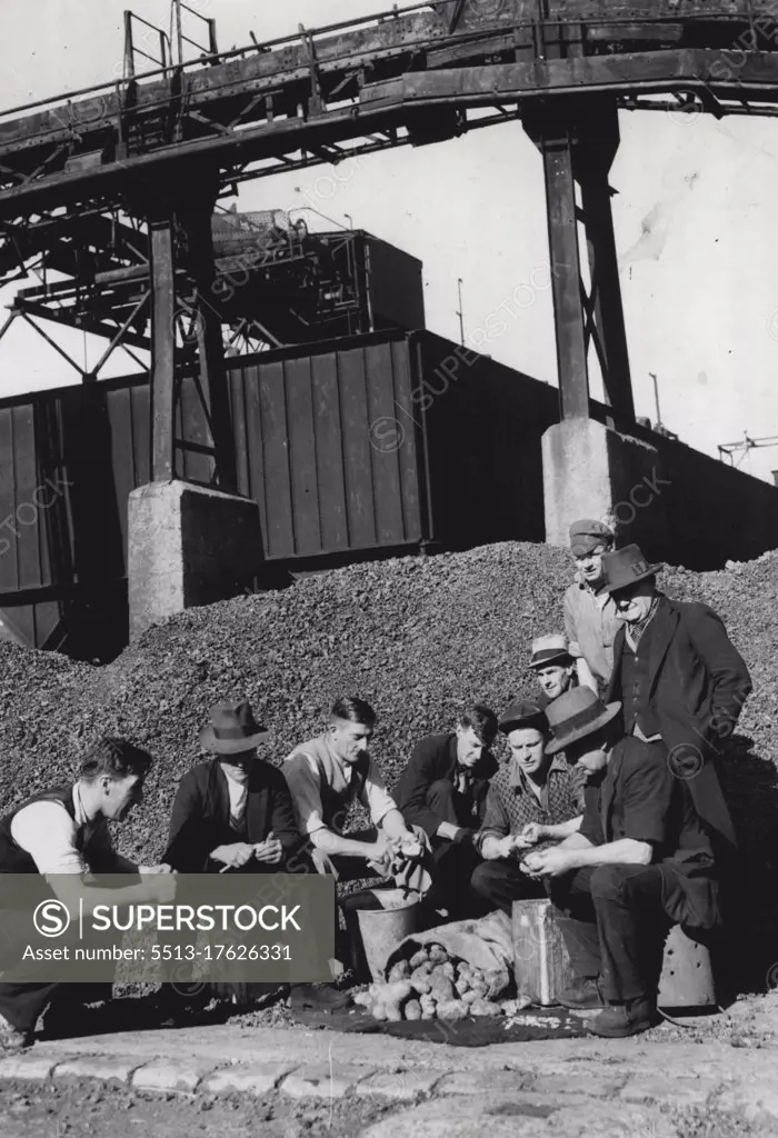 Against a background of machinery, stay-in strikers at the South Melbourne gas works peel potatoes for a meal. August 21, 1937. 