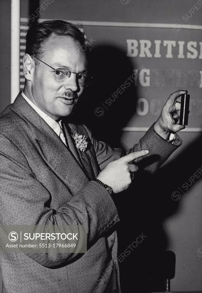 Atomic Fuel On Show At Olympic: 4 Inch Tube Equals 20,000 CWT, Of Coal  -- Mr. M. Whitehouse examines the solid bare of pure Uranium metal, on the stand of the British Engineer Association at the Engineering and Marine Exhibition being held at Olympia.The British Public can closely examine a solid bar of pure uranium metal shown on the stand of The British Engineer's Association at the Engineering and Marine Exhibition. It is believed that this is the first time the public has had an opportunity to see and handle the fuel for atomic power stations This small bar only few inches high, on loan from the U.K. Atomic Energy Authority is equivalent energy to about 20,000 sacks of coal ***** arrangements have been made to keep this specimen ***** special safe when the Exhibition closes each night. September 07, 1955. (Photo by Fox Photos).