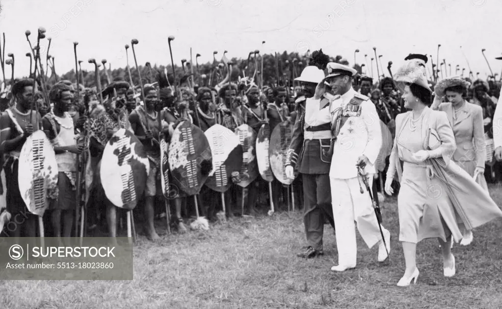 Their Majesties Inspected ***** Warriors -- The King salutes as Their Majesties, accompanied by the Paramount Chief Sobhuza Dlamini II, inspected some of the 4,000 Swazi warrior who assembled March 25. The Paramount Chief was arrayed in the height of the military fashion of the second empire, in an Azure tunic, scarlet trousers, gold epaulettes and a yellow diagonal sash.During his tour of South Africa the late King met these Swazi warriors in full war dress. The late King is accompanied by Queen Elizabeth and the new Queen. July 23, 1947.