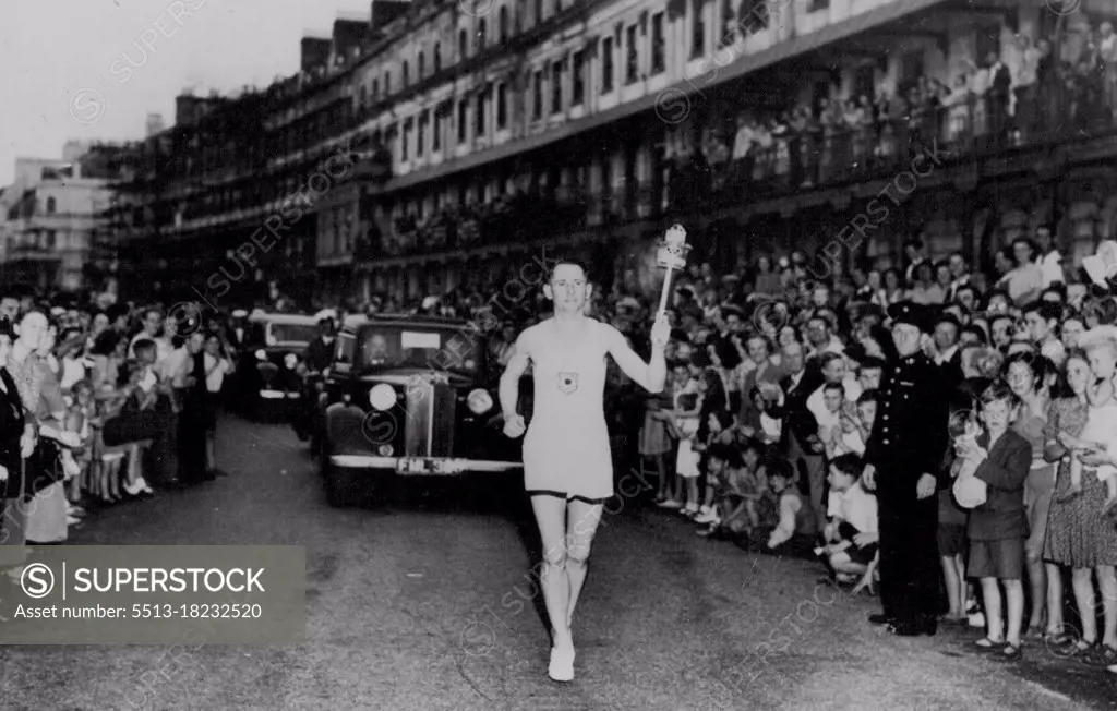 SP Olympics 1948 - London Olympic Torch -- Peet Officer Barney Barnes who had the honor of bearing the torch ashore speed along Dover front on the first stage of its journey to-night to Wimbley. Olympic Flame arrives in Britain. July 28, 1948. (Photo by Reuterphoto).