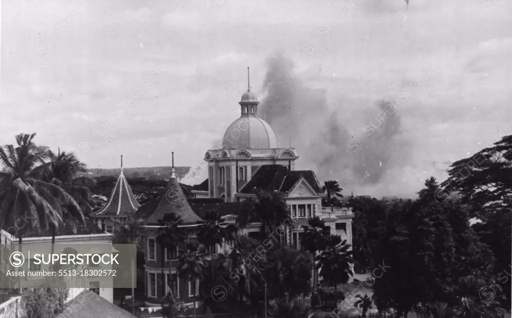 Damage done by Japanese bombs on the island of Singapore.Fires in the distance started by Japanese bombs. February 19, 1942.