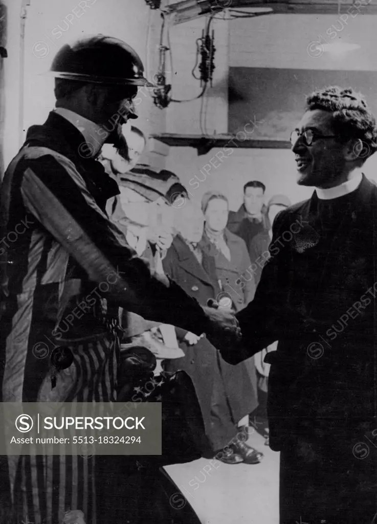 This picture, taken on Christmas Eve 1940, during the height of London's blitz, shows the Rev. William Sangster welcoming Mr. Bowen McCoy, dressed as "Santa Sam" on his rounds of some of the underground shelters. Mr. McCoy who was an executive official of the American Red Cross in London distributed toys to children in the shelters. April 21, 1954. (Photo by Associated Press Ltd.).