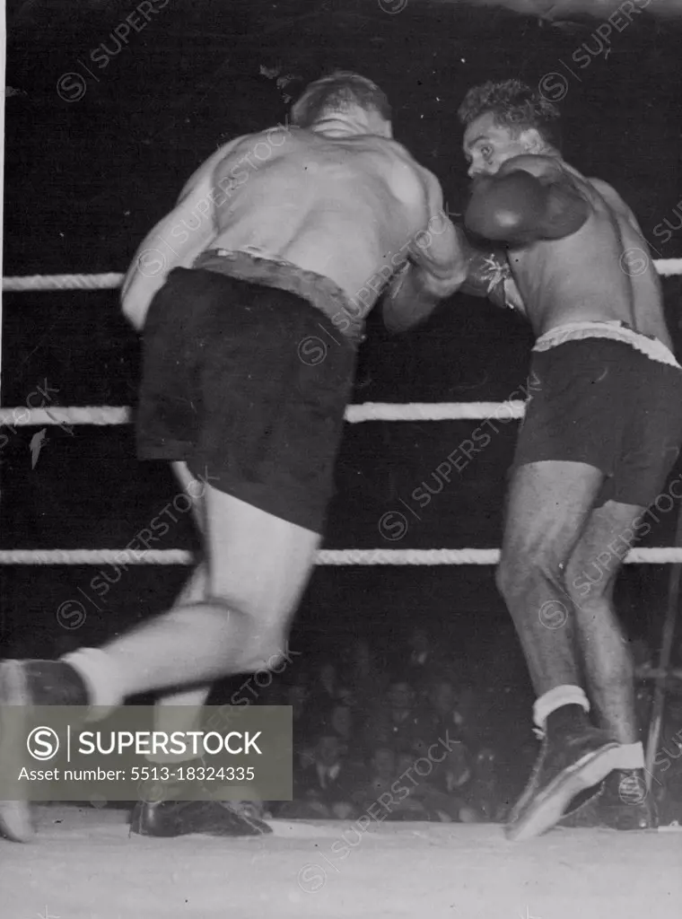 Sands V Mullett Fight At Wellington, N.Z. -- Mullett throws a solid right-hand punch, which Sands avoids by moving slightly to the left.NZ Fight. New Zealand heavyweight champion. Don Mullett, throws a solid right, which fails to connect, in his recent bout with Australian title holder Dave Sands. Sands won on points. April 10, 1948.