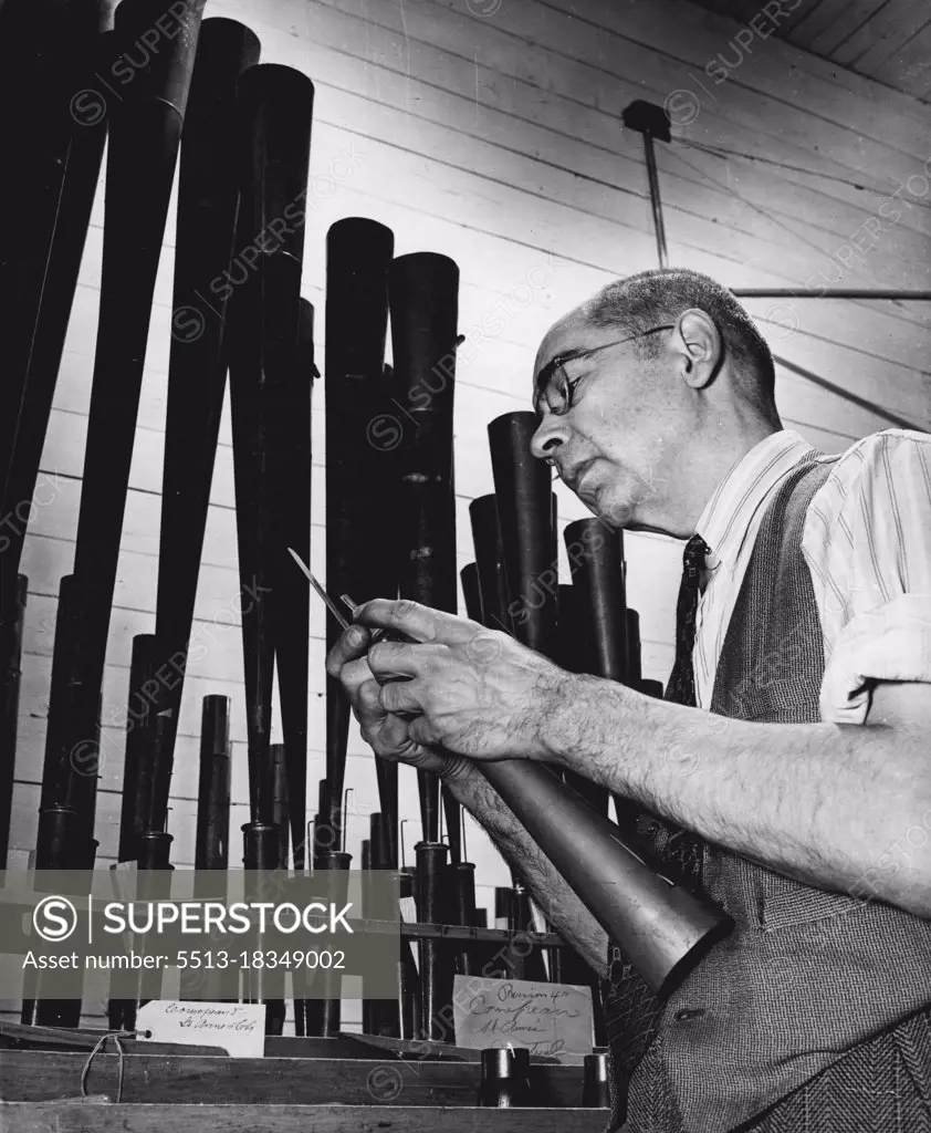 Organ Builders: Eusebe N. Gaudette commands the noisiest room in the Casavant plant. He"voices" read and other pipes - makes them "speak" - to adjust and tune them. The pitch of a pipe is determined by its length. The Casavant plant installed the organ in Blumenthal Castle, Paris. January 31, 1951. (Photo by Malak, Camera Press).