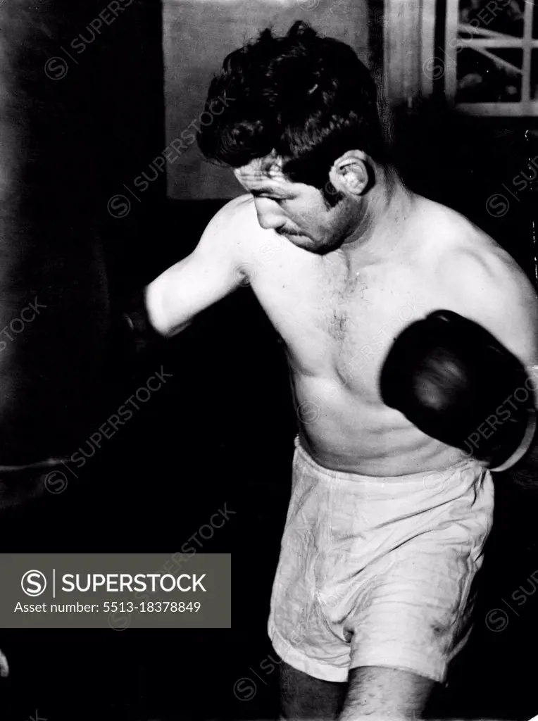 Don Johnson shows determination as he punches the bag in training for his return bout with Alf Sands next Monday night. September 9, 1953.