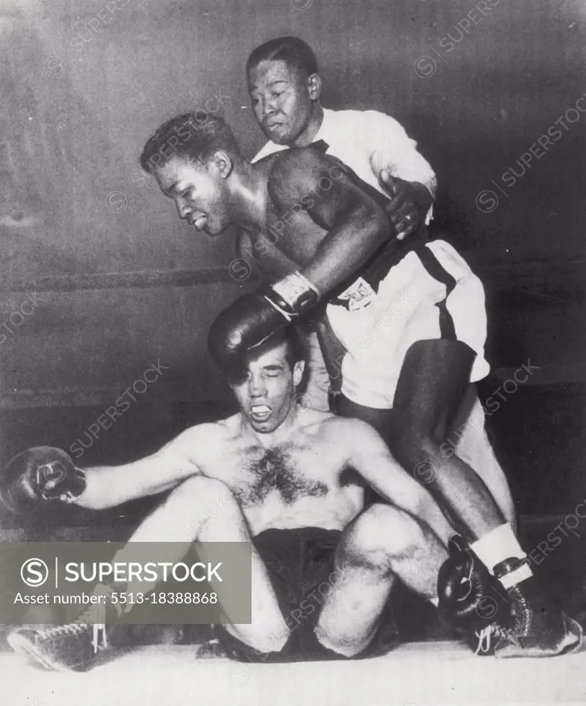 Paddy Hits The Deck -- Paddy De Marco, Brooklyn lightweight, is low man on the totem pole as he is floored by Arthur King of Toronto in the fourth round of their ten-rounder at Brooklyn's Eastern Parkway Arena here tonight. Referee Jimmy Freeman reaches over to hold King, who nearly stumbles over his fallen foe. King, Claimant to the British Empire lightweight title, won an upset victory by unanimous decision over the favored De Marco. May 26, 1952. (Photo by AP Wirephoto).