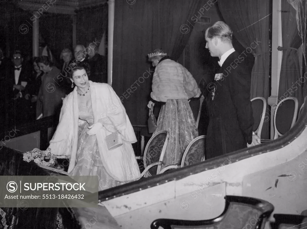 A Smile For The Duke -- The fur-coated Queen Elizabeth the second, turns with a smile of encouragement for the Duke of Edinburgh, right, as they arrive in the Royal box at London's Royal Albert Hall tonight for a concert in aid of British and Nether lands flood relief funds. March 04, 1953. (Photo by Reuterphoto).