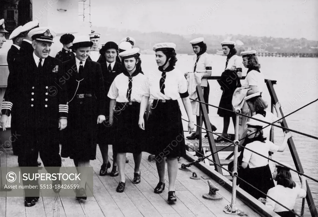 The Princesses Come Aboard : The Princesses, followed by Windsor Sea Rangers of the crew of M.T.B. 630, escorted by Captain Nicholl on the quarter-deck of H.M.S. Duke of York at Devonport yesterday (Wednesday). Princess Elizabeth and Princess Margaret, who are spending a few days aboard the Sea Rangers' training ship M.T.B. 630 in the River Dart, Devon, went with the ship's company by bus to Devonport, where they were entertained by Captain A. Nicholl, R.N. on board the battleship H.M.S. Duke of York for lunch and tea. July 25, 1946.