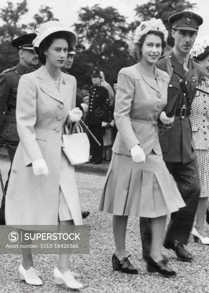 Royal Family Visits Sandhurst : King Presents New Colours To College. Princess Elizabeth, wearing a floral hat (right) with Princess Margaret Rose (left) wearing an off-the-race hat with a full length coat, arrive to watch the King present new colours to the Royal Military Academy, at Sandhurst. June 14, 1947.