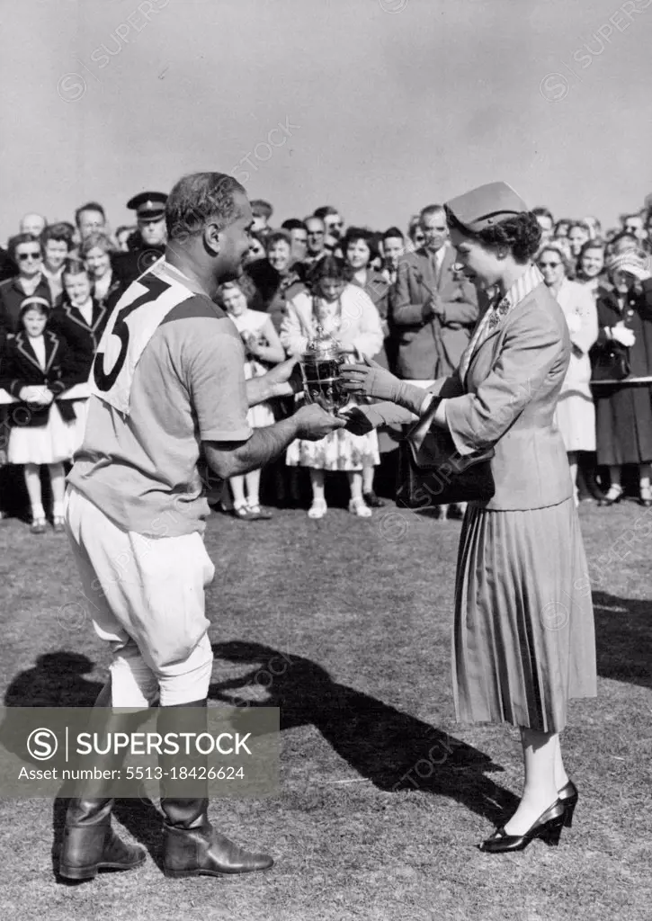 Royal Family see finals of Windsor Polo week. H. M. The Queen seen presenting the Royal Windsor Cup to Rao Rajah Ranut Singh, whose team Ratanada beat Ham in the final this afternoon. At Windsor today, the final matches of the Household Brigade Ascot Week Polo Tournament were played. Members of the Royal Family, who have been enthusiastic spectators at the matches throughout the week, were again watching today and the Royal Party included King Hussein and Queen Dina of Jordan who are visiting this country. June 18, 1955. (Photo by Fox Photos).