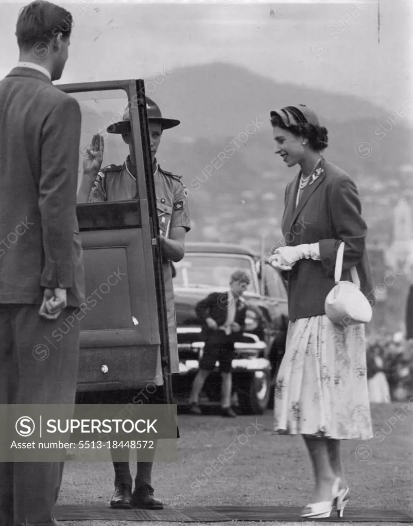 Salute. A boy Scout salutes the Queen as she enters her car in Hobart yesterday. The Queen had attended an ex-servicemn's rally. February 22, 1954.